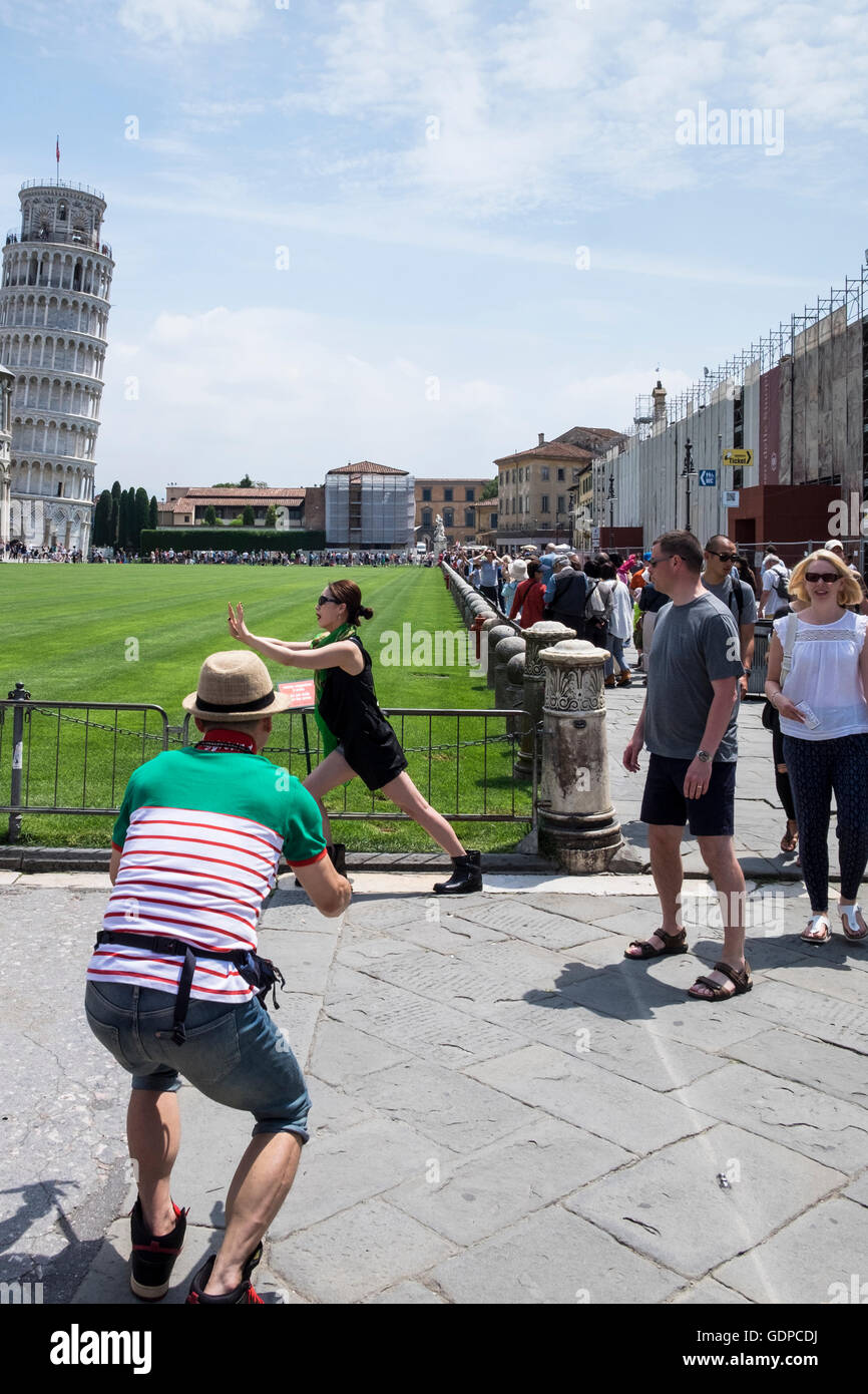 I turisti alla torre pendente di Pisa in posa di assurdo pone per le fotografie, Pisa, Toscana, Italia Foto Stock