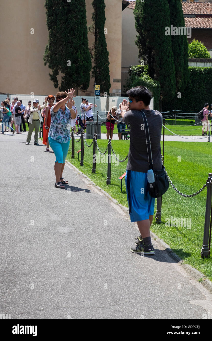 I turisti alla torre pendente di Pisa in posa di assurdo pone per le fotografie, Pisa, Toscana, Italia Foto Stock