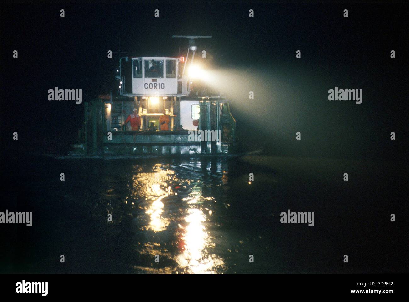 Spintore la barca con una chiatta per il trasporto di merci in navigazione sul fiume Po (Italia) Foto Stock