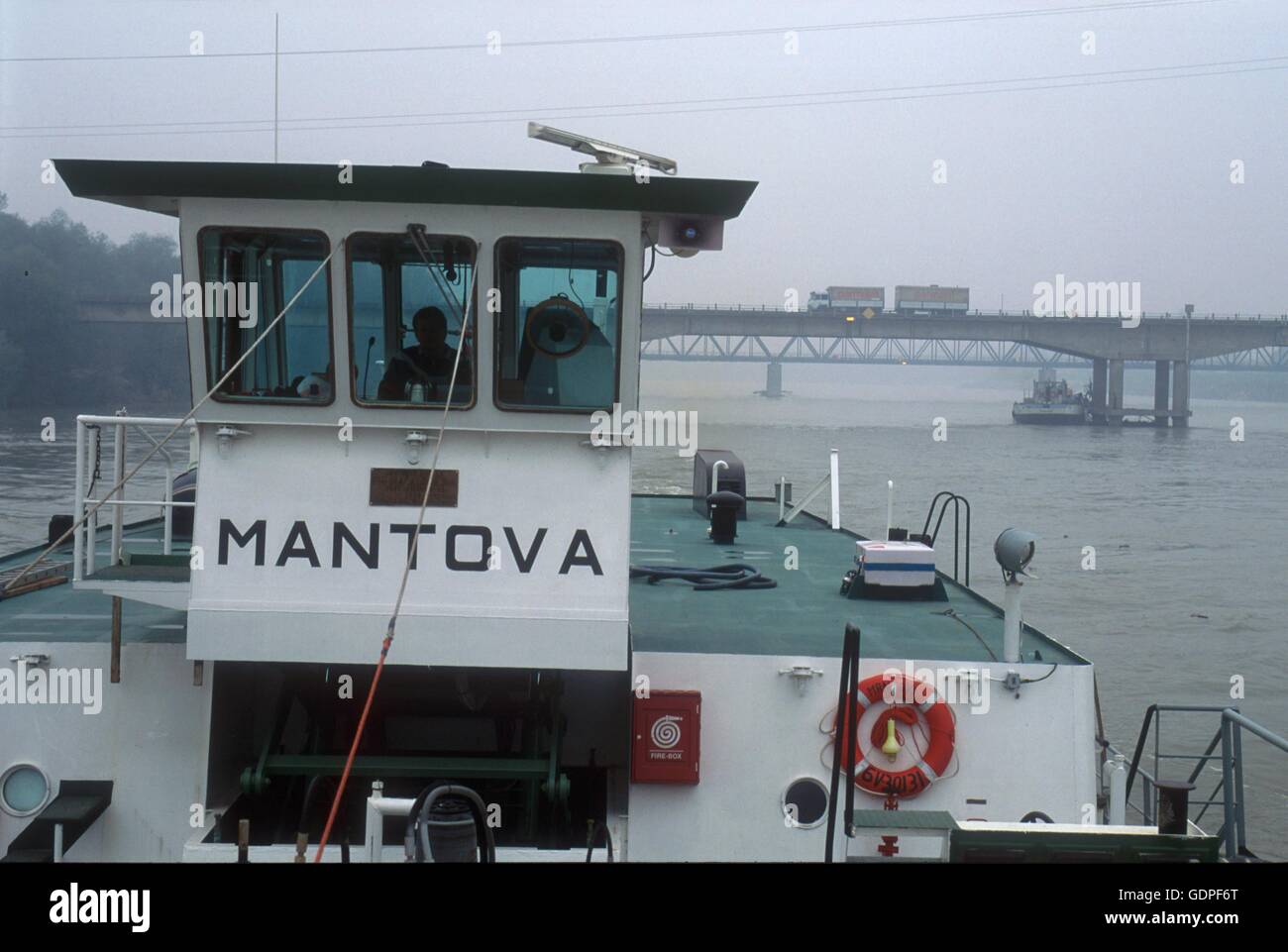 Spintore la barca con una chiatta per il trasporto di merci in navigazione sul fiume Po (Italia) Foto Stock