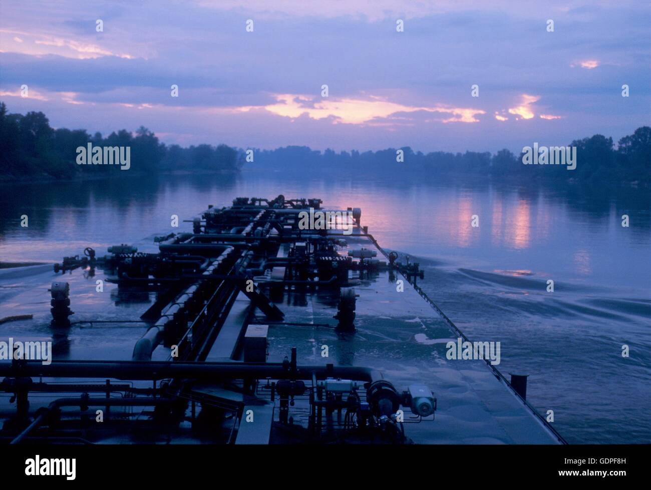 Spintore la barca con una chiatta per il trasporto di merci in navigazione sul fiume Po (Italia) Foto Stock