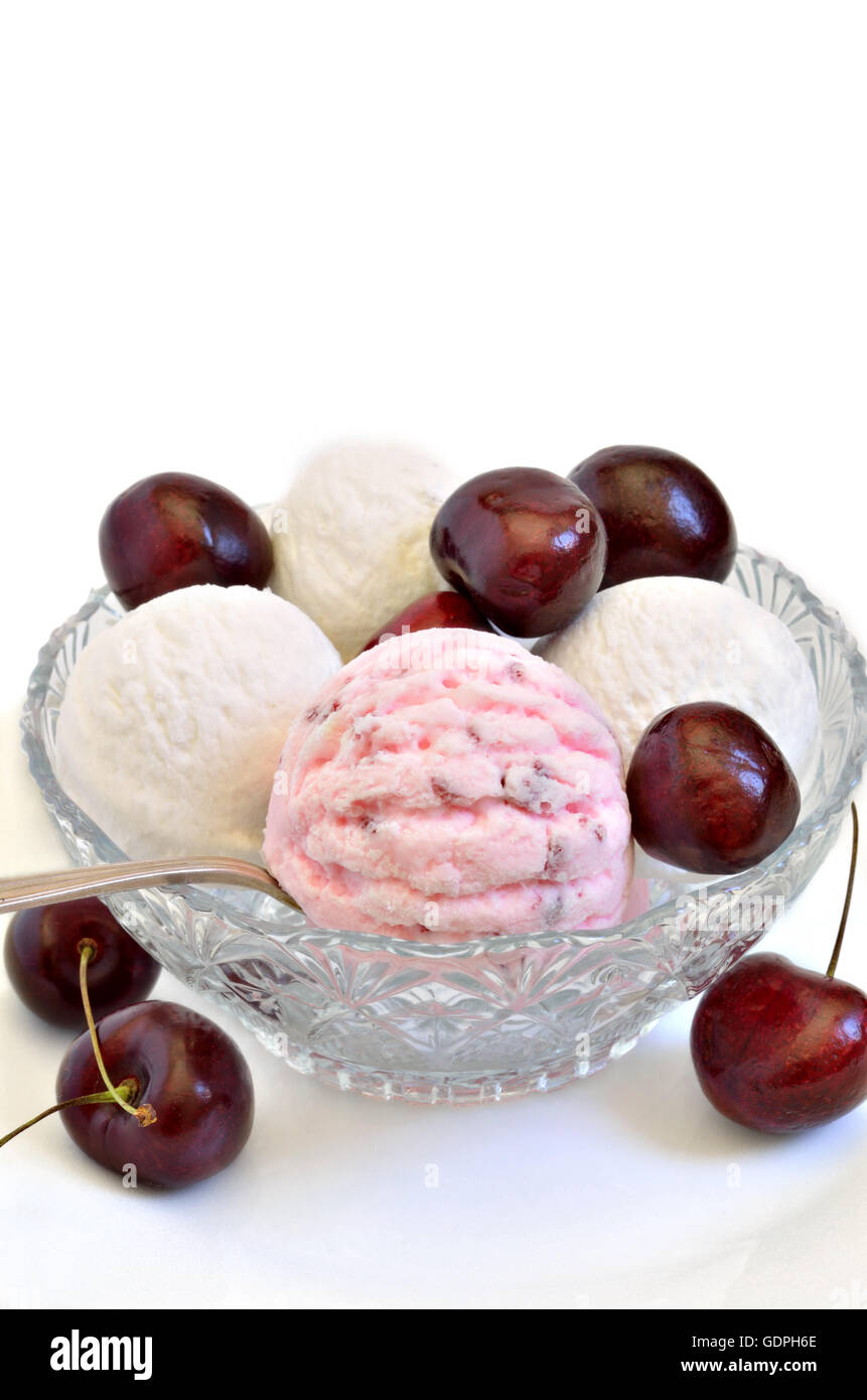 La ciliegia del gelato e gelato alla vaniglia con ciliegie fresche in una ciotola, close up, macro, sfondo bianco, verticale Foto Stock