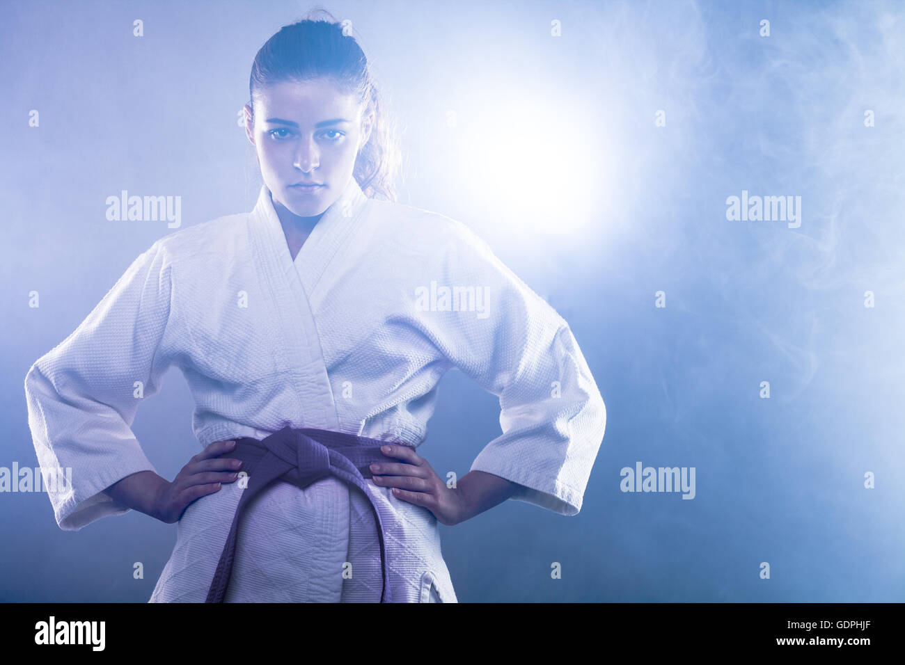 Fiducioso donna che indossa il Karate Kimono con le sue mani sui fianchi Foto Stock