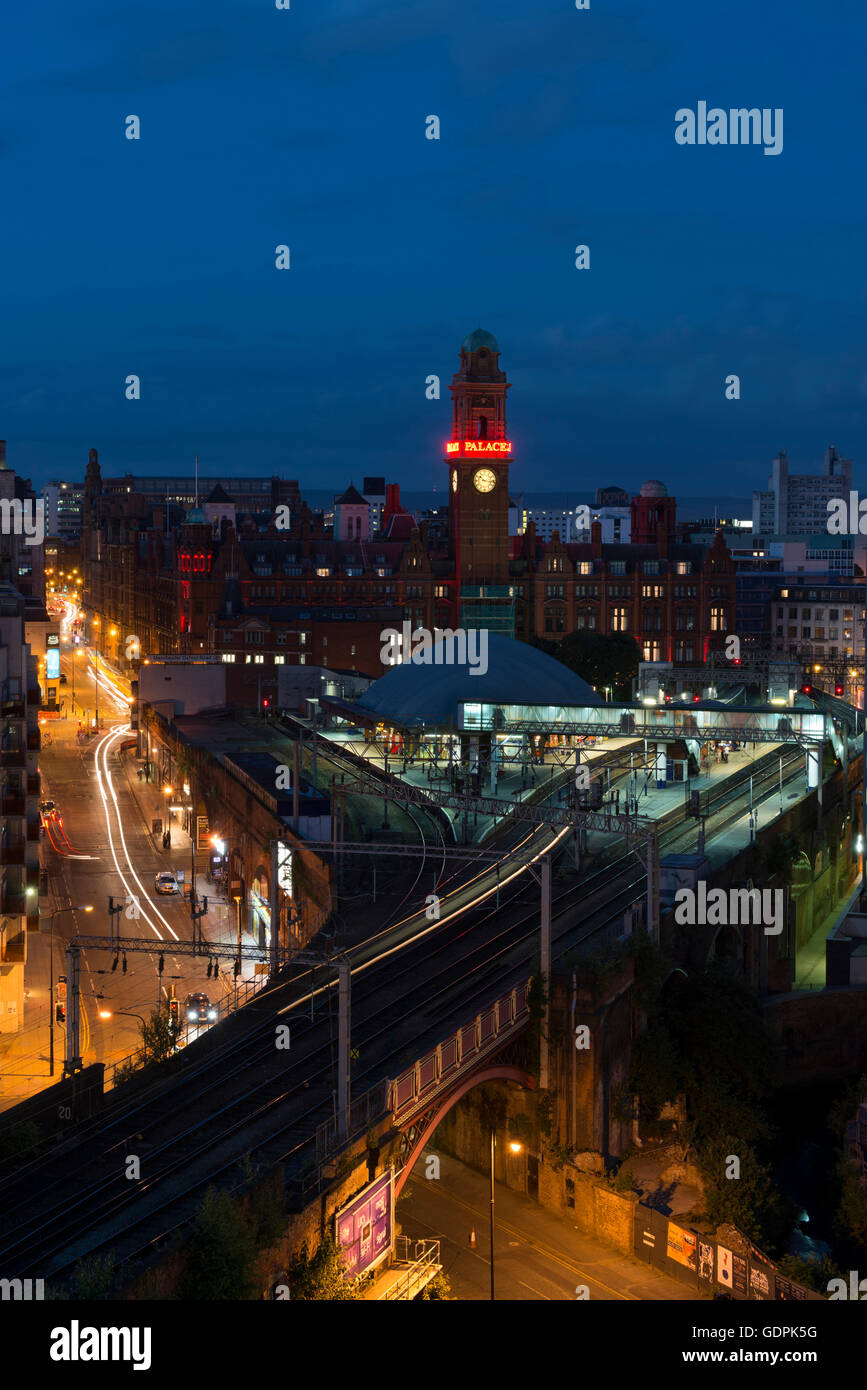 Lo skyline di Manchester con il traffico stradale e i treni nei pressi di Oxford Road station da Whitworth Street West nel centro della città di notte. Foto Stock