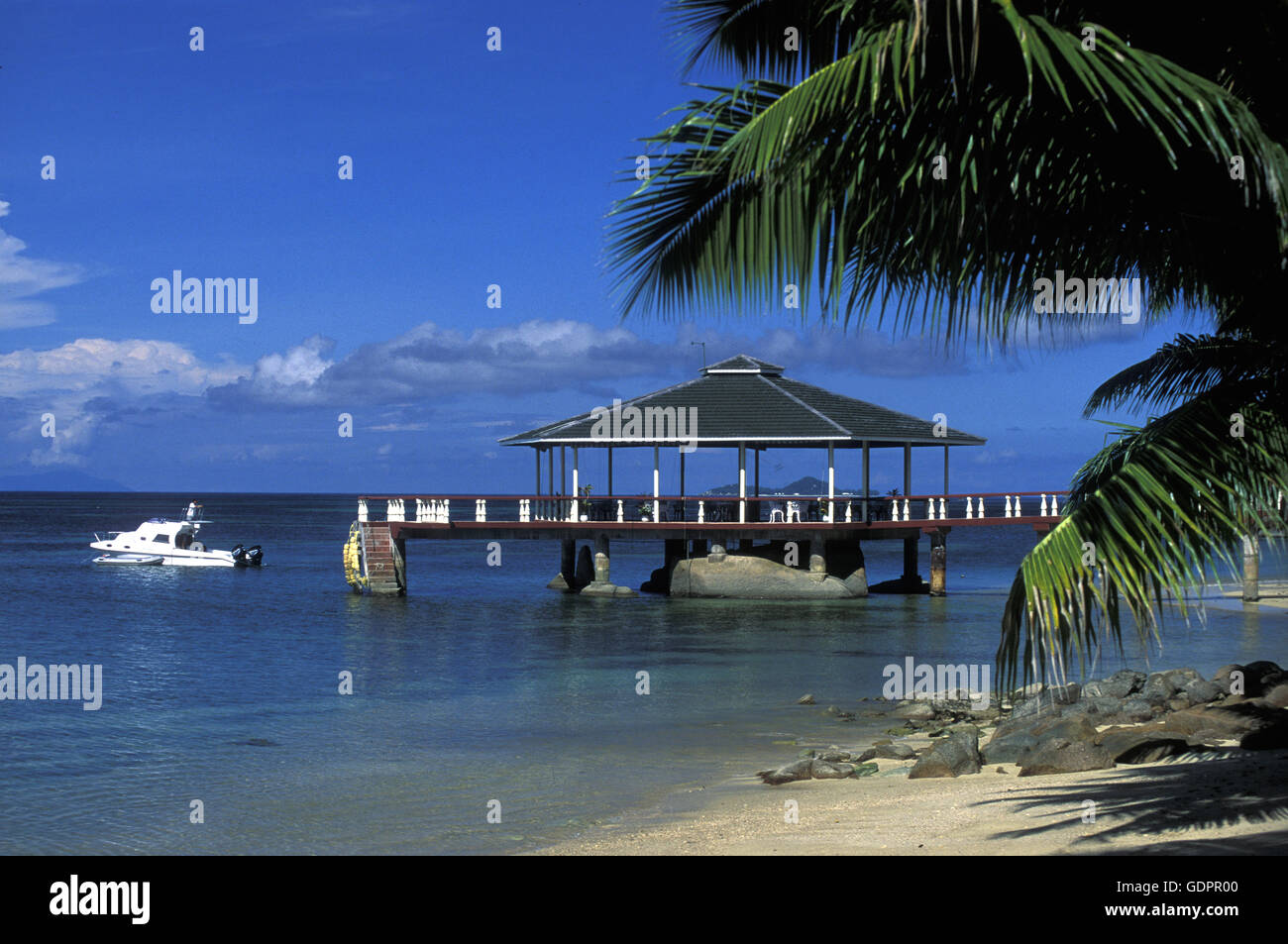 Ein Hotelstrand mit Pavillon bei Sonnenuntergang auf der Insel Praslin auf den Seychellen im Indischen Ozean. Foto Stock