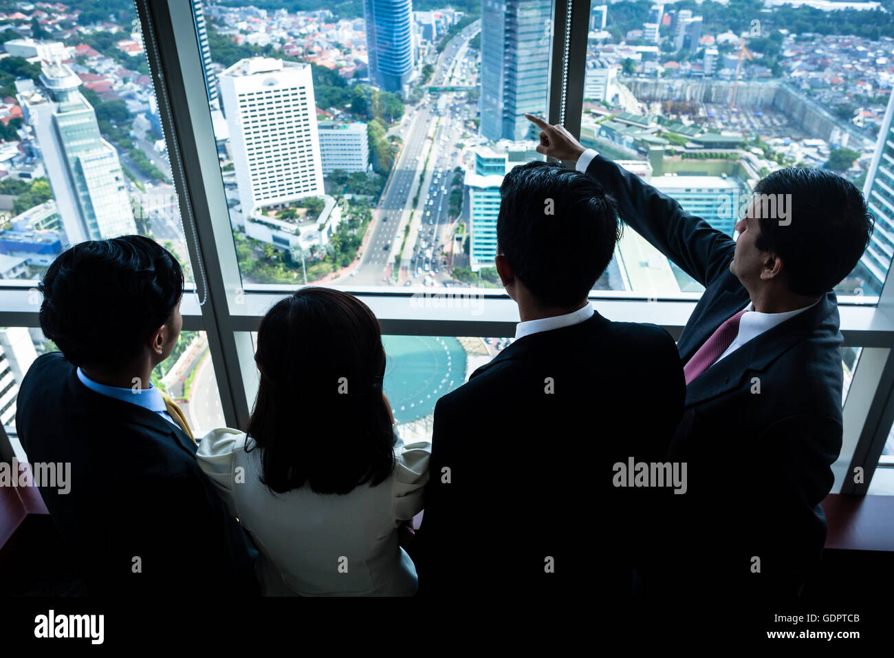 Gruppo di Asian business immobiliare persone guardando skyline della città dal grattacielo edificio per uffici Foto Stock