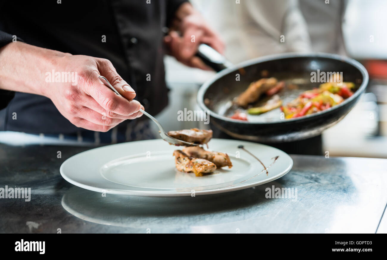 Chef cibo di finitura sulla piastra in ristorante o hotel cucina Foto Stock