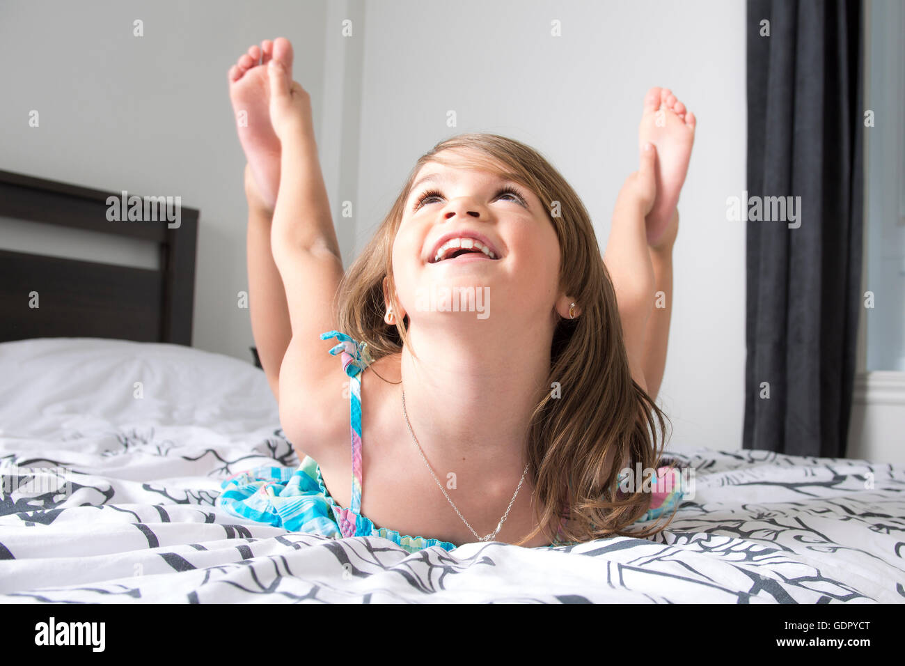 Ritratto di bella bambina giacente sul letto Foto Stock