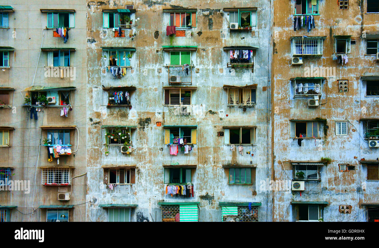 Impressione scena di muro di cemento dal vecchio edificio di appartamenti, gruppo della finestra di età, condizionatore aria e il downgrade di blocco Foto Stock