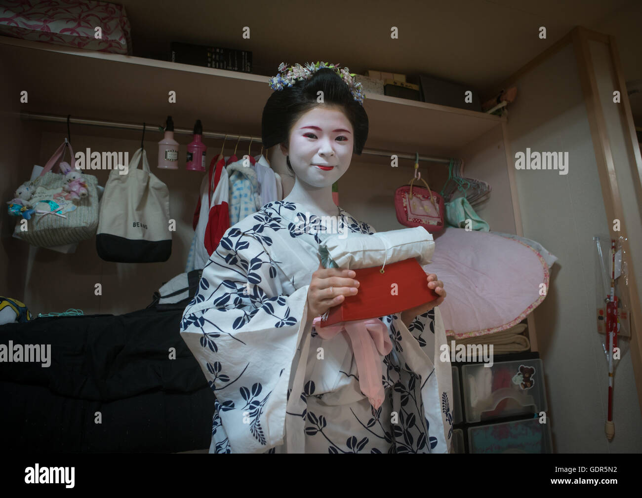 16 anni maiko chikasaya chiamato con il cuscino shes utilizza per proteggere la sua acconciatura, regione di Kansai, Kyoto, Giappone Foto Stock