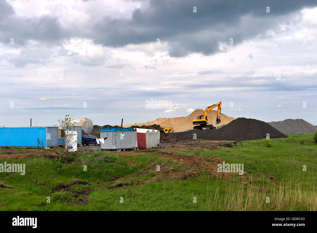 Escavatore giallo lavorando a scavare nella cava di sabbia Foto Stock