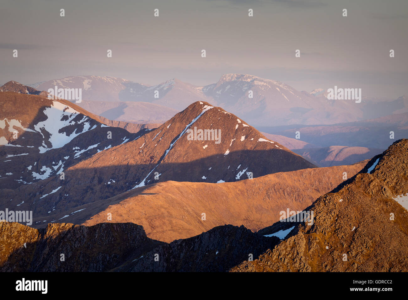 Interplay tra luce e ombra su Sgurr an Locain al tramonto, Glen Shiel, s een dalle cinque sorelle di Kintail Foto Stock