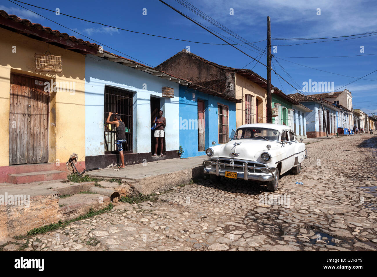 Scenario di strada, Strada tipica con ciottoli, case colorate e auto d'epoca, il centro storico, Trinidad Foto Stock