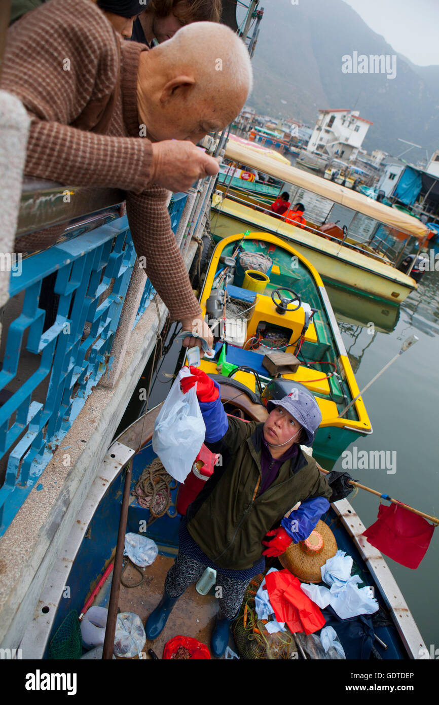 La gente acquista presso un mercato galleggiante in Tai O, l'Isola di Lantau, Hong Kong. Foto Stock