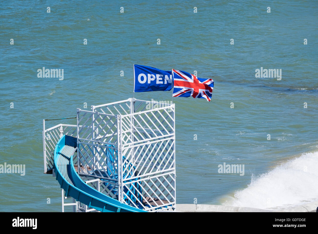 Un "Union Jack Flag' e 'Open' battenti bandiera insieme sulla cima di un Helter Skelter ride a Cromer in Norfolk Foto Stock