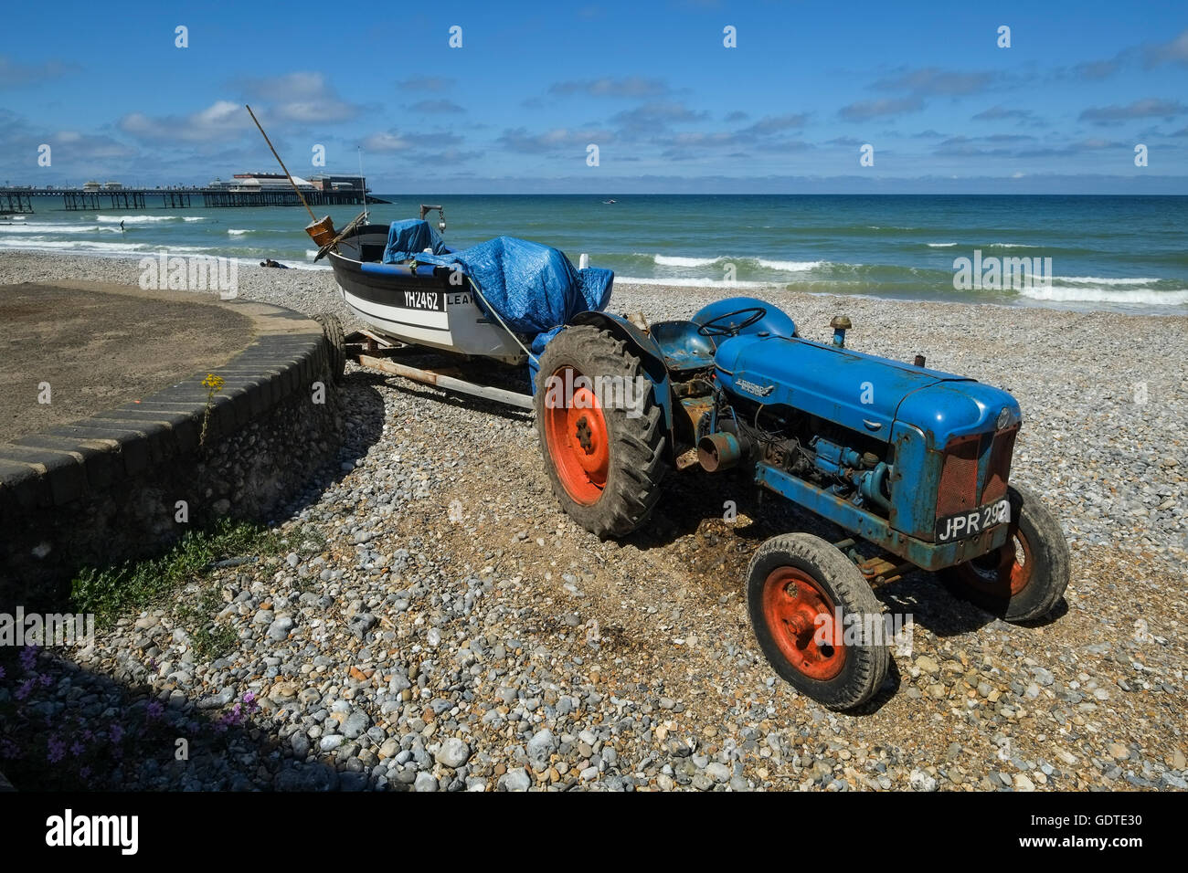 Vecchio trattore e barca sulla spiaggia a Cromer in Norfolk Foto Stock