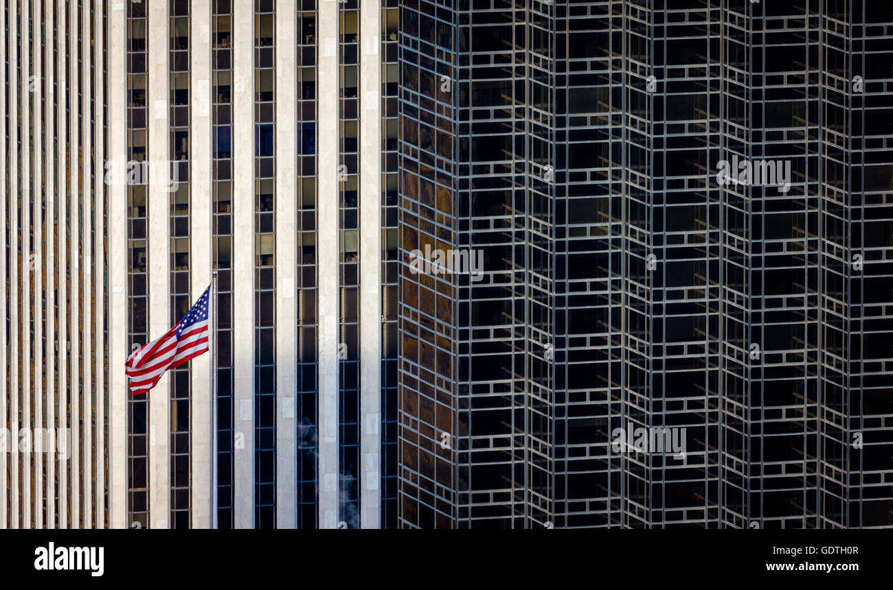 Bandiera americana e contrasto architettonico tra New York City grattacieli di Manhattan Foto Stock