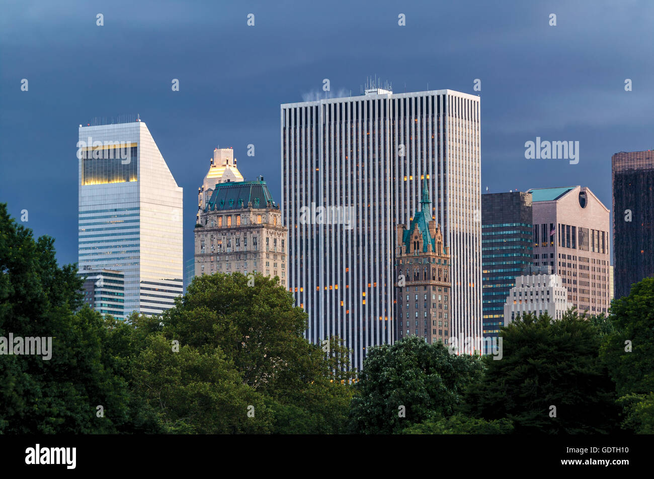New York City edifici e grattacieli al tramonto visto dal Central Park (Manhattan Midtown) con un tempestoso del cielo della sera Foto Stock