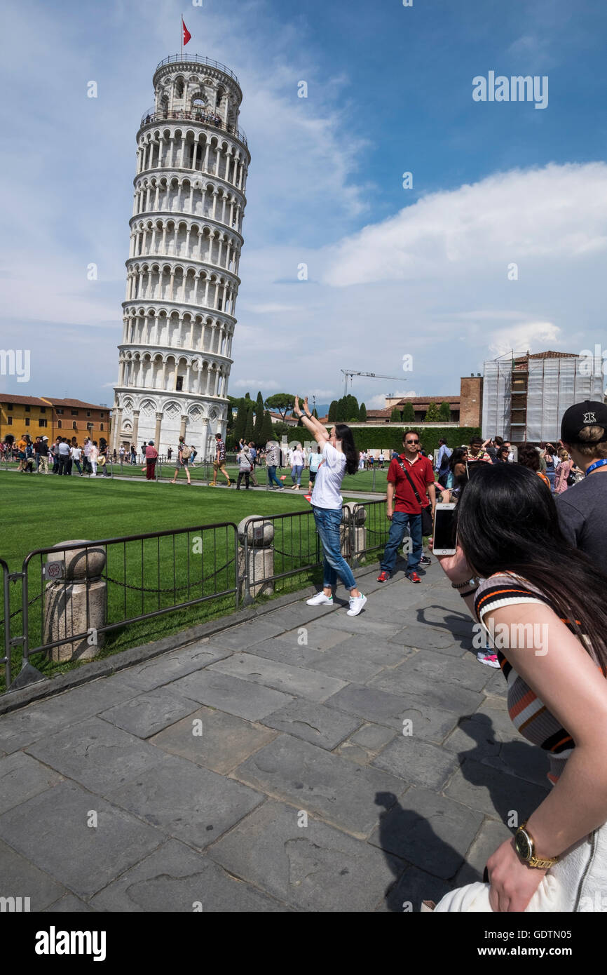 I turisti alla torre pendente di Pisa in posa di assurdo pone per le fotografie, Pisa, Toscana, Italia Foto Stock