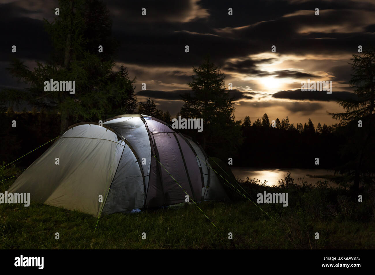 Tenda contro la montagna di notte Foto Stock