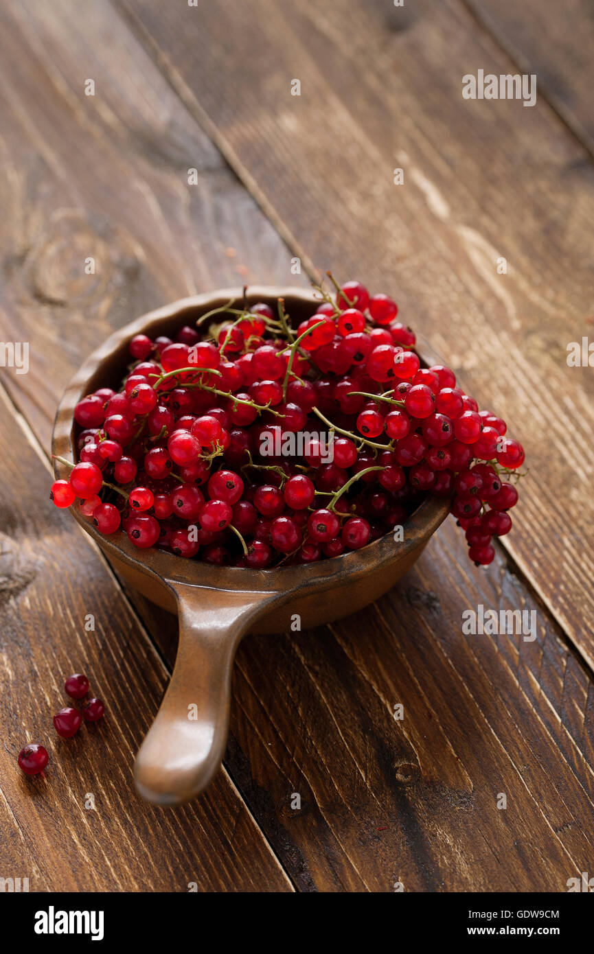Ribes rosso in una ciotola sul tavolo di legno Foto Stock