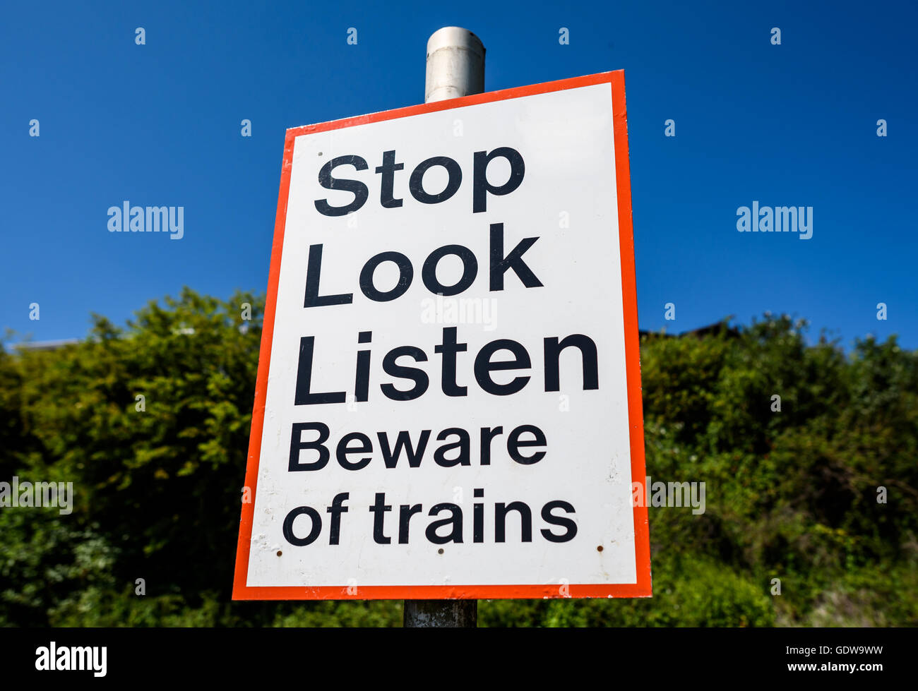 Una linea ferroviaria attraversamento pedonale segno avviso in Inghilterra. Foto Stock