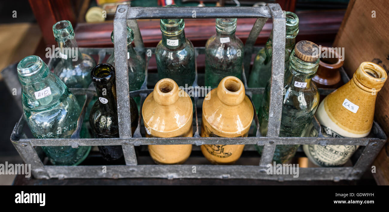 Una selezione di vetro antico e bottiglie in ceramica in un negozio. Foto Stock
