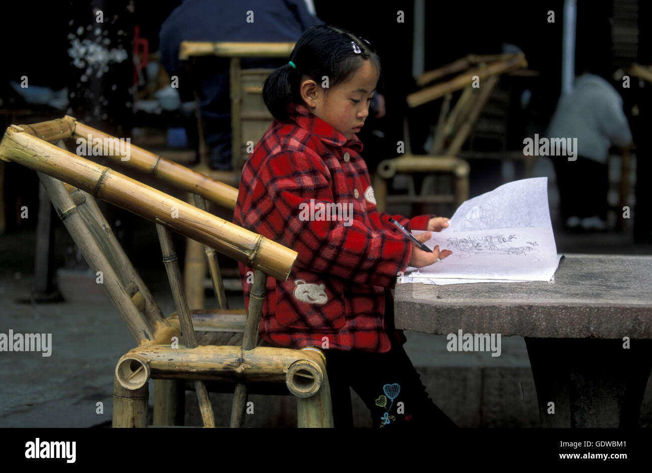 Un bambino è lerning per la scuola in un parco nella città di Chengdu in provinz Sichuan in Cina centrall. Foto Stock