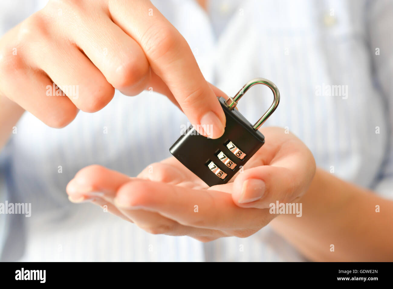 Business donna tenendo un blocco cifrato nelle sue mani suggerendo le assicurazioni sulla vita o la sicurezza personale Foto Stock