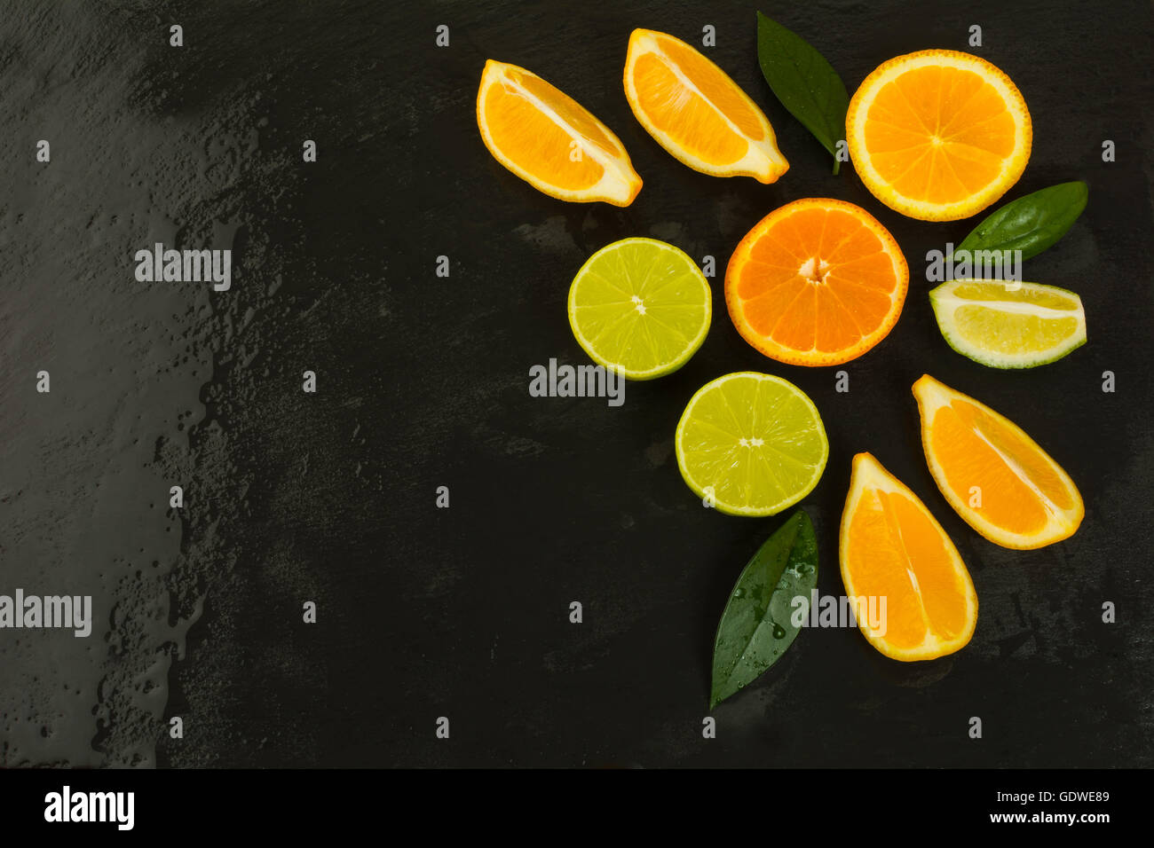 Detox concetto con limone, arancio e calce su sfondo nero. Mangiare sano concetto con mature di agrumi misti. Lime, limone e o Foto Stock