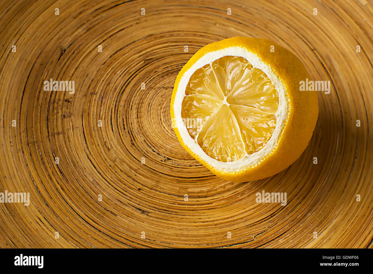 Limone in ciotola di legno. Dolce Limone essiccato su sfondo di legno. La metà di un limone giallo Foto Stock