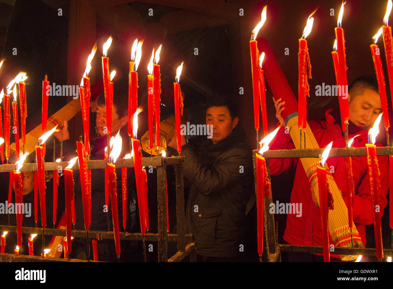I fedeli accendono le candele in un tempio taoista al quinto giorno del Capodanno cinese Foto Stock