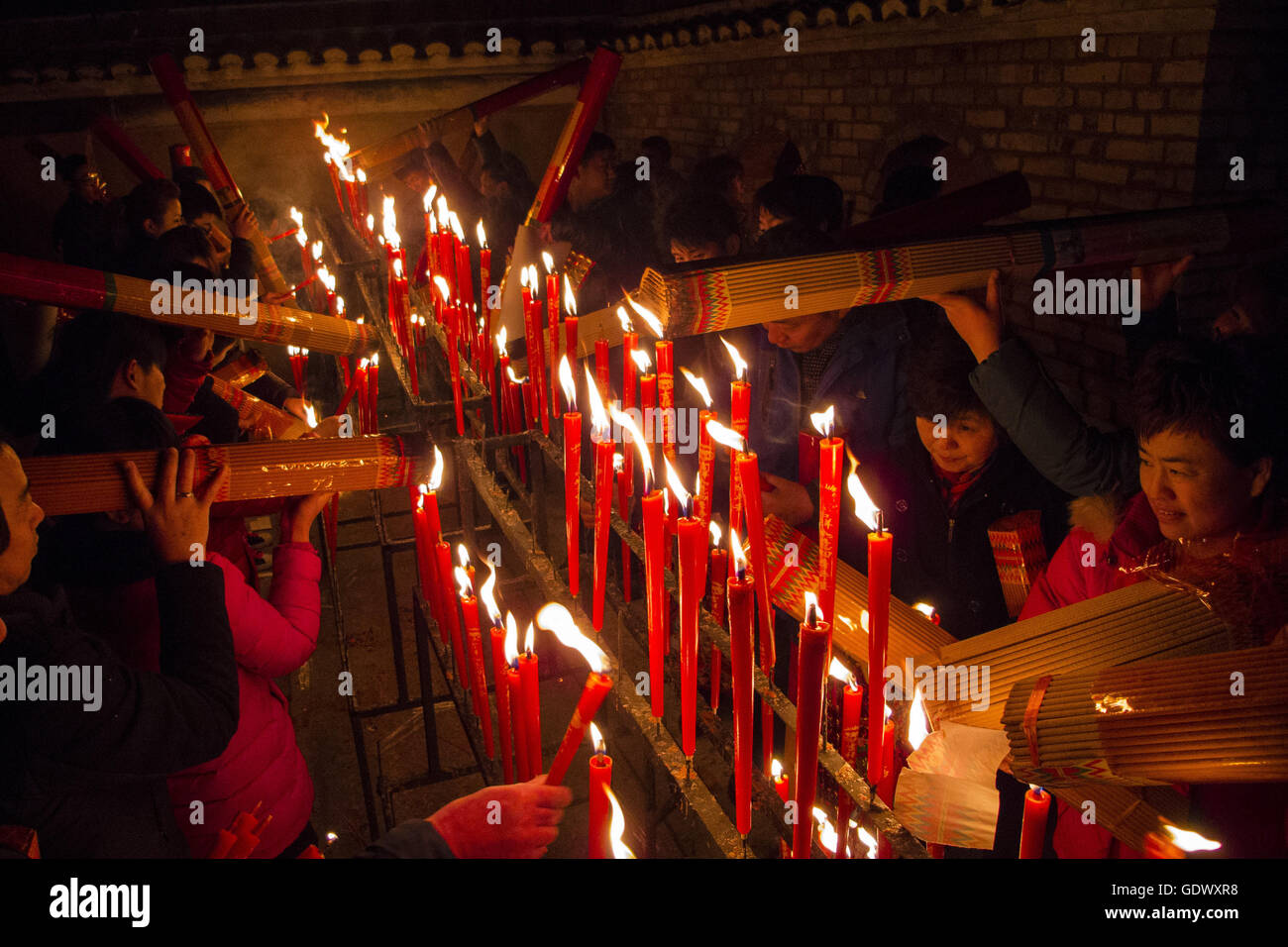 I fedeli accendono le candele in un tempio taoista al quinto giorno del Capodanno cinese Foto Stock