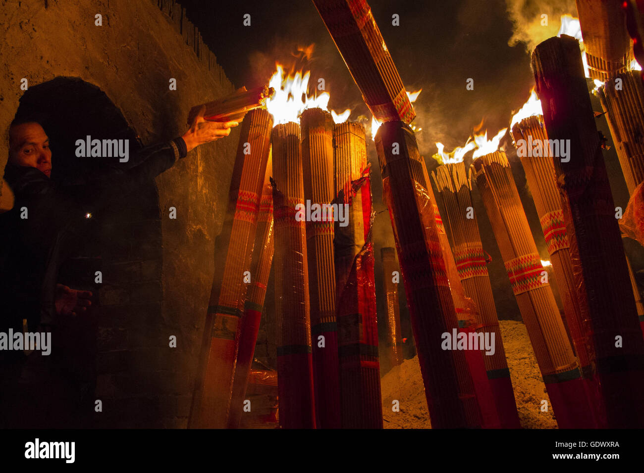I fedeli accendono le candele in un tempio taoista al quinto giorno del Capodanno cinese Foto Stock