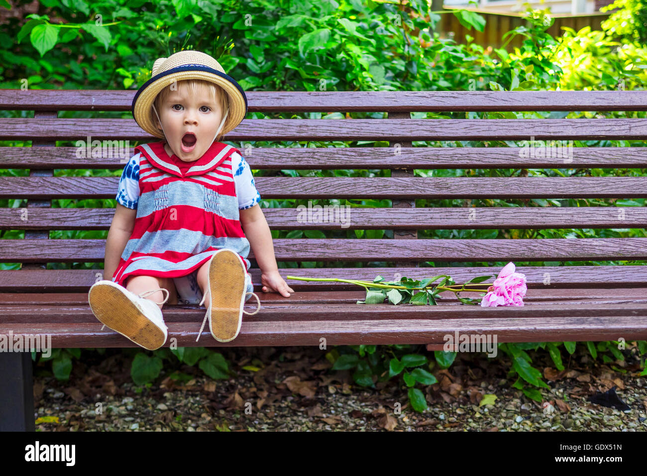 Carino bambina sbadigliare mentre è seduto sul banco di lavoro Foto Stock