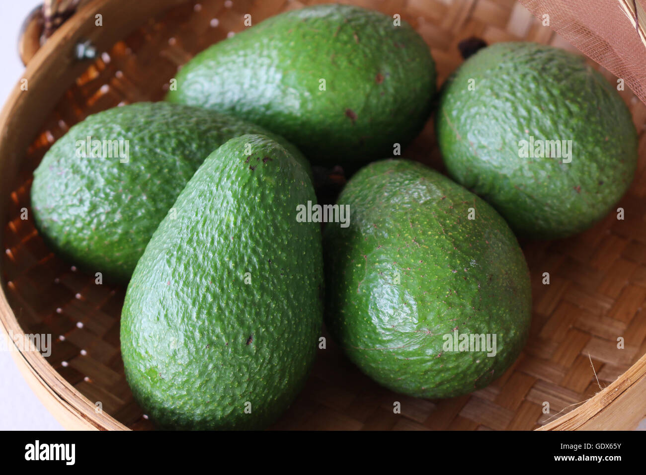 Appena raccolti cresciuti organicamente 'Hass' Avocado in una ciotola di tessuto. Foto Stock