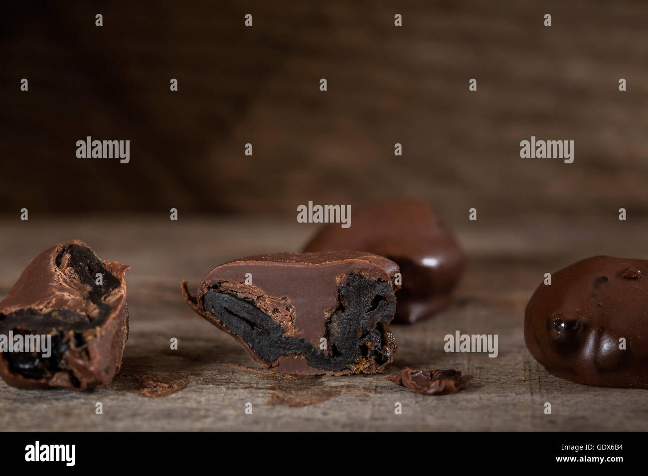 Le prugne di cioccolato sulla rustico sfondo di legno Foto Stock