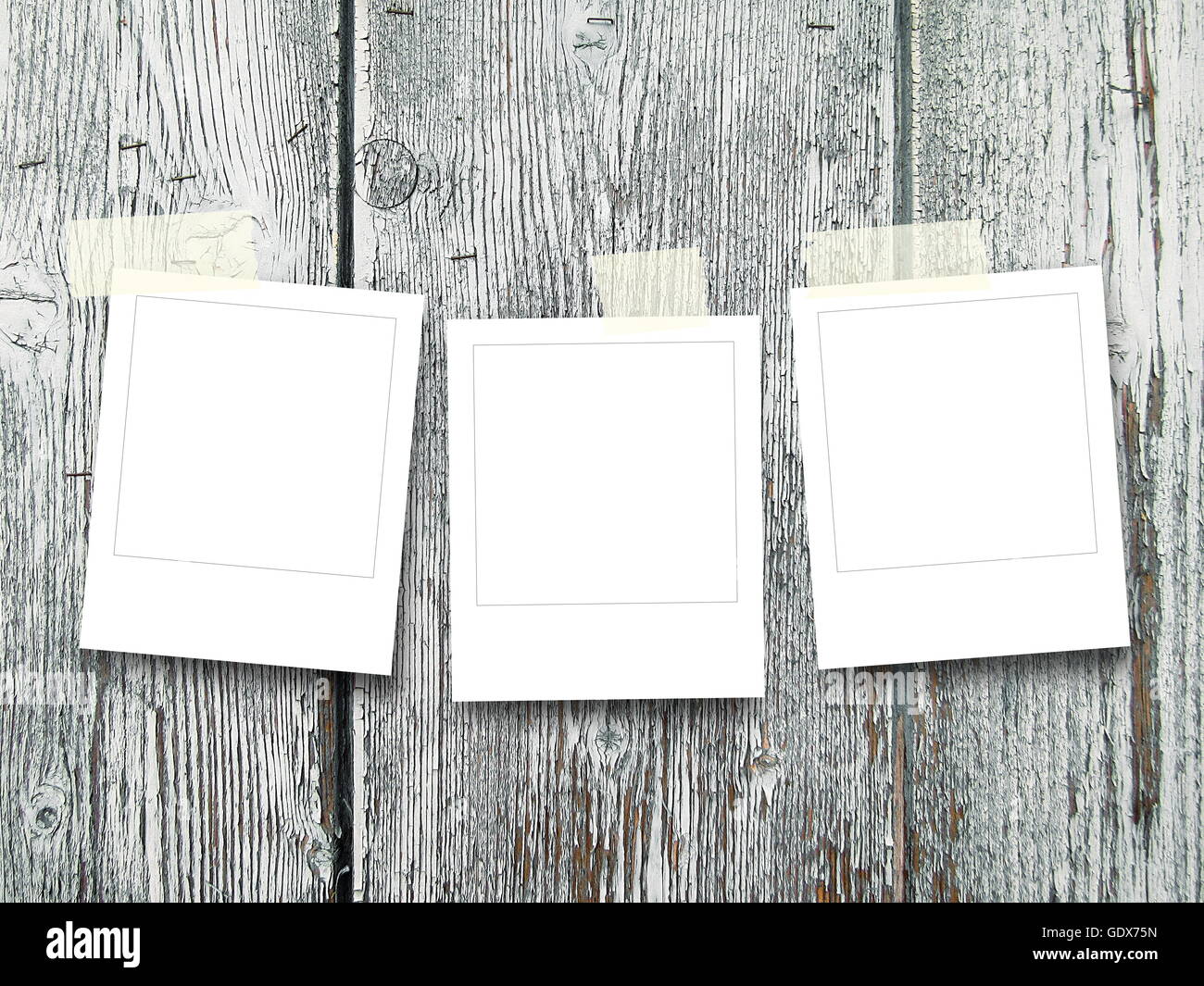 Close-up di tre quadrato bianco instant photo frame con nastro adesivo su grigio di tavole di legno sfondo Foto Stock