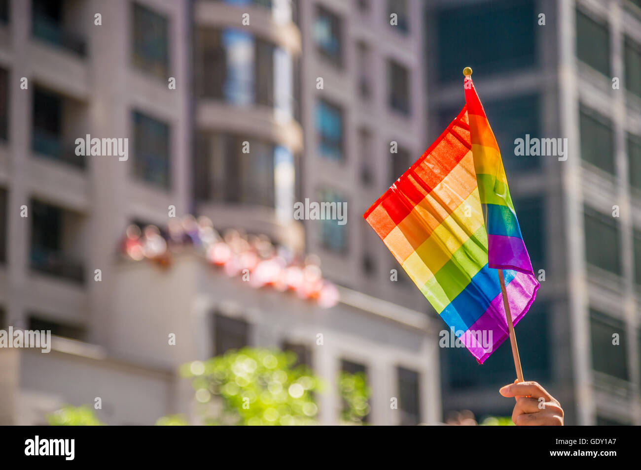 Mano che tiene un gay rainblow bandiera con copyspace Foto Stock