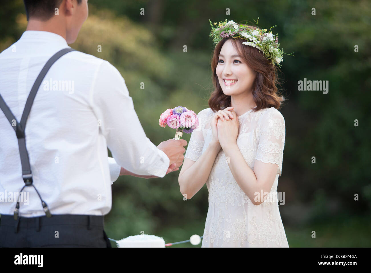 Ritratto di sposa sorridente parlando un bouquet da sposo Foto Stock