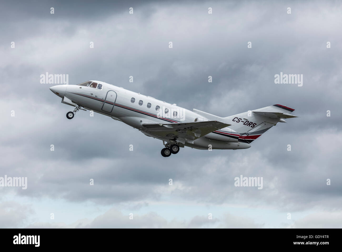 Raytheon Hawker 800 xpi jet executive in una nuvola sky decollare da Farnborough Airport in Hampshire Foto Stock