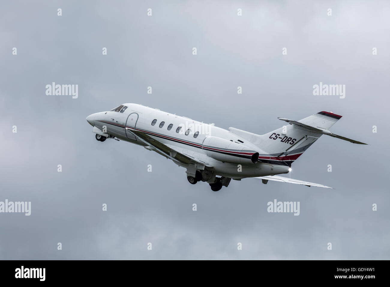 Raytheon Hawker 800 xpi jet executive in una nuvola sky decollare da Farnborough Airport in Hampshire Foto Stock