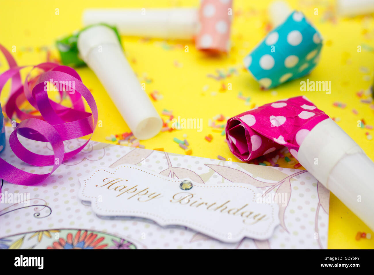 Parte di corna (fischietti) e buon compleanno scheda su sfondo giallo Foto Stock