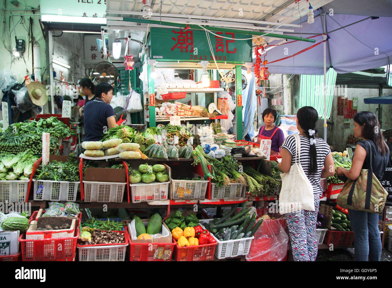 Le donne di shopping in un vegetale in stallo a Hong Kong street market Foto Stock