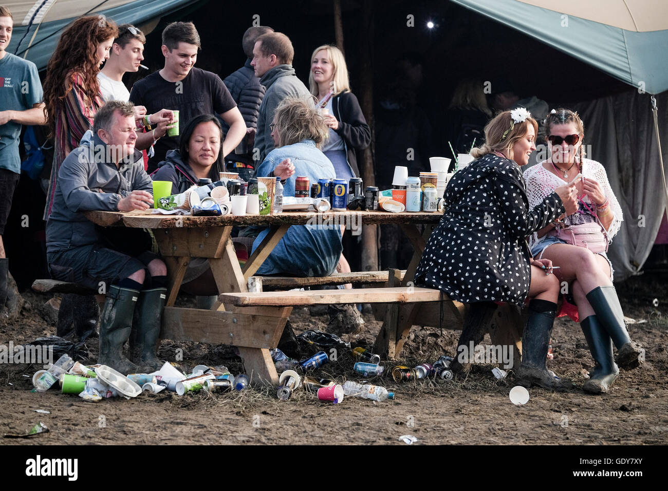 Glastonbury Festival il 23/06/2016 presso l'azienda agricola degna, Pilton. Nella foto: i frequentatori del festival mangiare e bere intorno a un tavolo disordinato Foto Stock