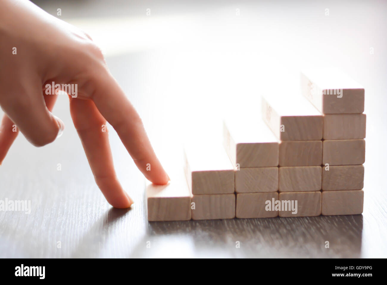 Mano a salire le scale realizzate con blocchi di legno Foto Stock