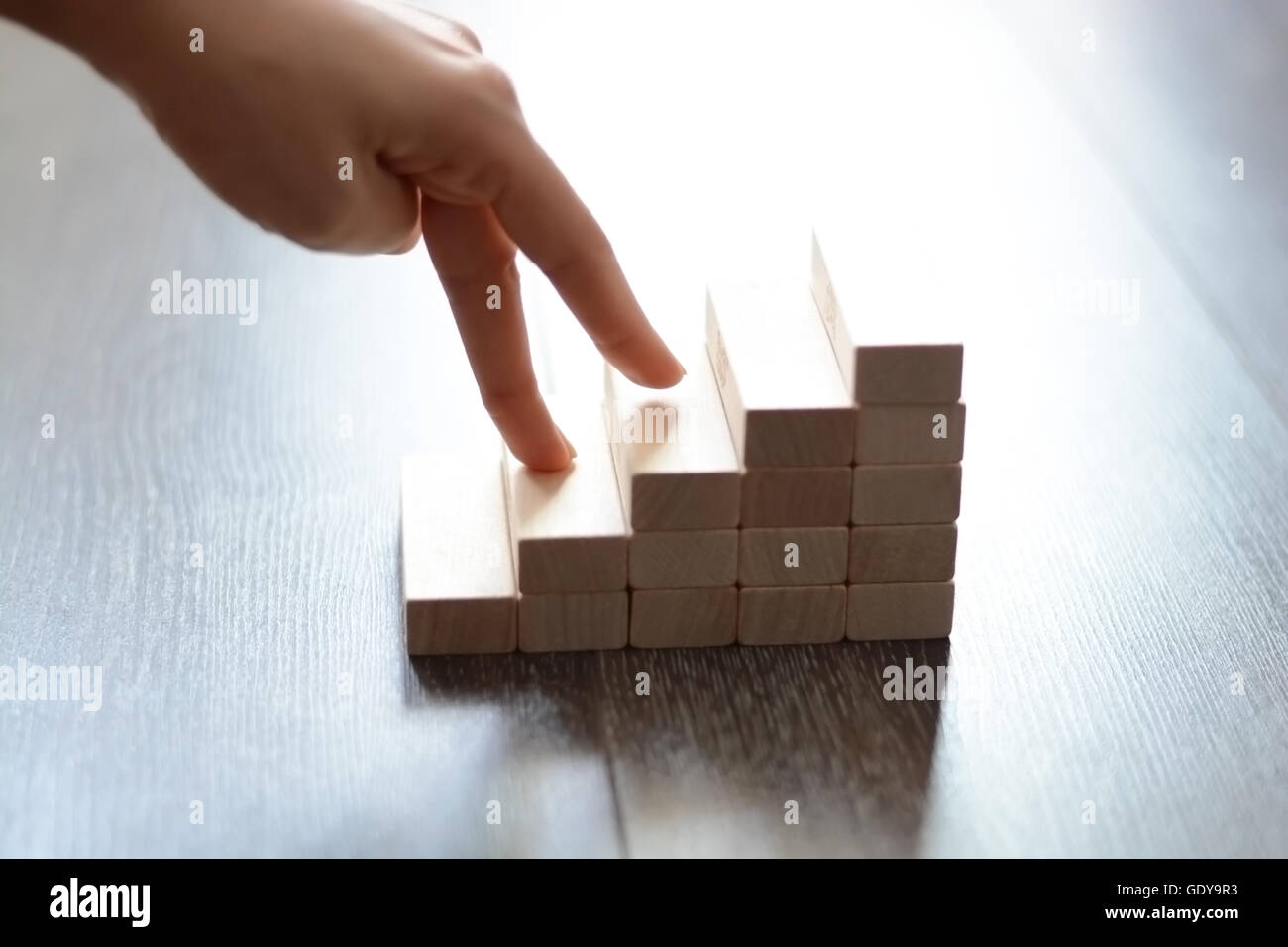 Mano a salire le scale realizzate con blocchi di legno Foto Stock