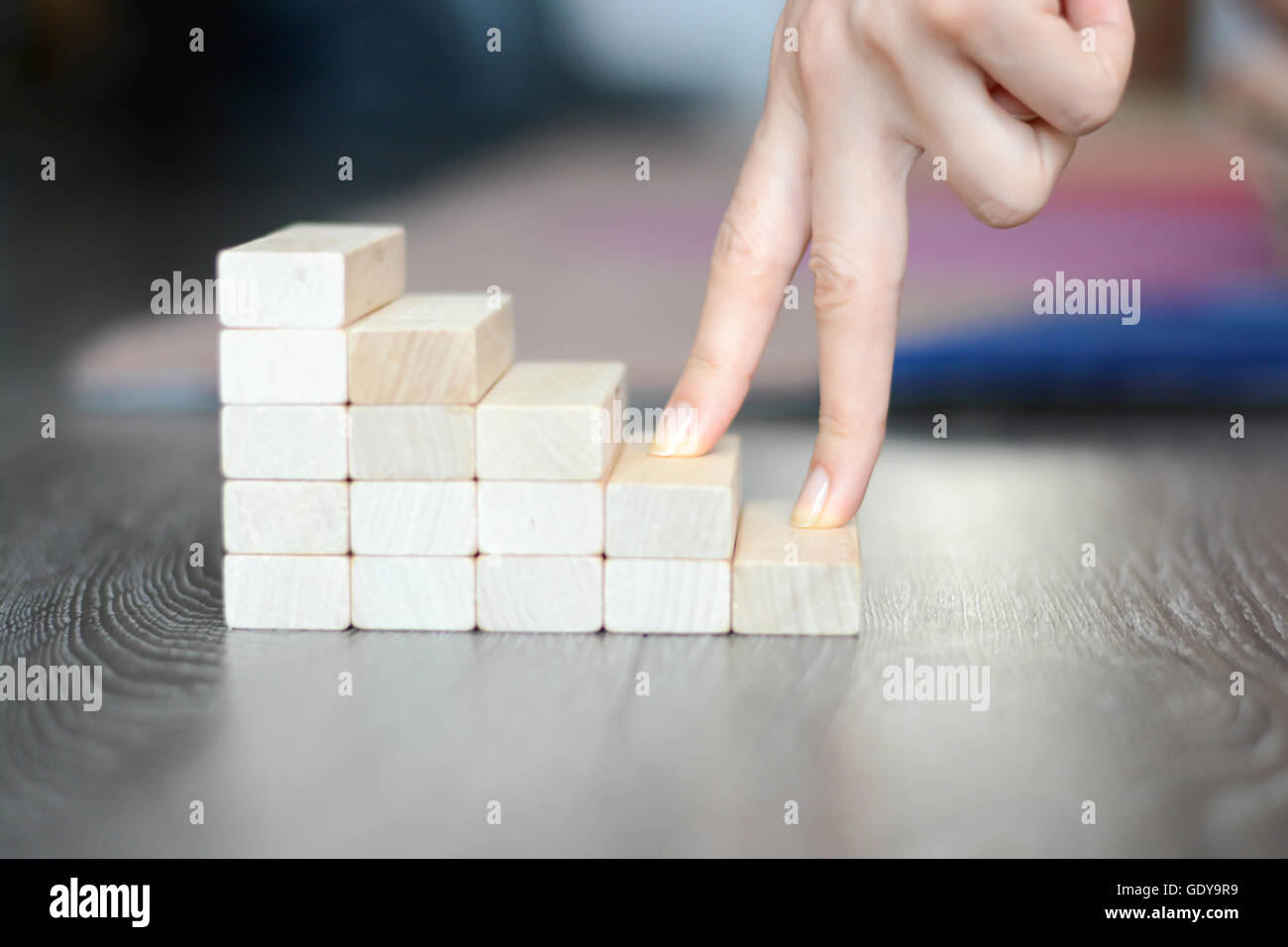 Mano a salire le scale realizzate con blocchi di legno Foto Stock