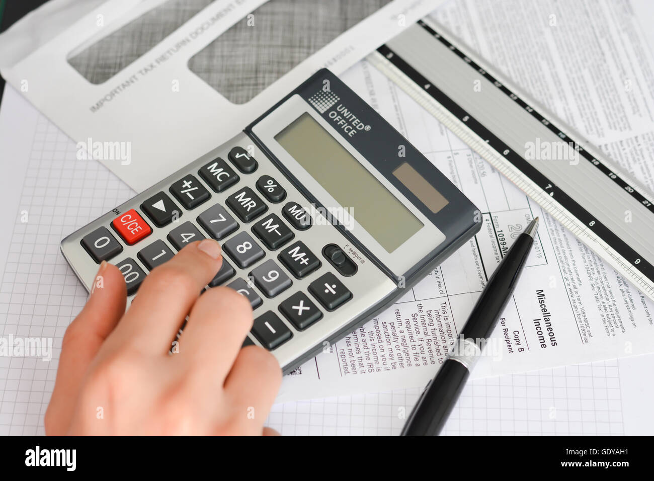 Moduli fiscali con la penna, Busta e calcolatrice suggerendo annuale di finanziamento delle operazioni Foto Stock