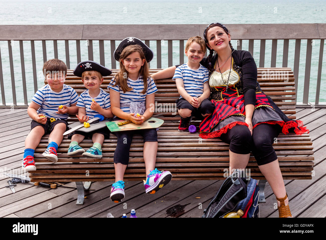 Una famiglia vestito in costume pirata di mangiare il loro pranzo a Hastings Pier durante l'Hastings giorno pirata Festival, Hastings, Regno Unito Foto Stock
